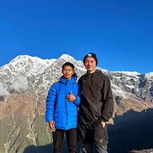 two men standing in front of a mountain