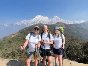 a group of people with hiking poles and backpacks on a mountain